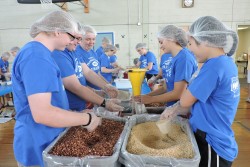 Honors students working to pack meals of beans and rice for children in Nigeria.