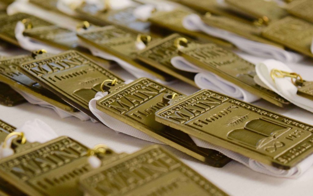 Numerous Honors medallions displayed on a table.