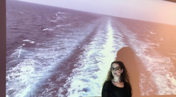 Samantha Jones is shown with a projection of the ocean